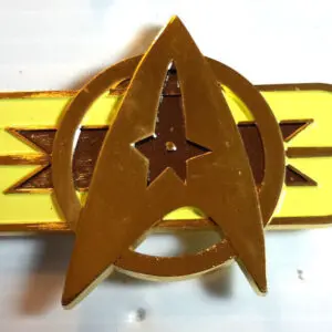 Gold Starfleet command pin with yellow stripe.