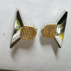 Two silver and gold triangular earrings.