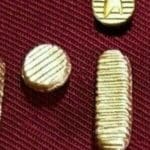 Gold buttons on a red fabric background.