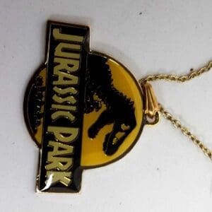 Gold Jurassic Park necklace with dinosaur logo.