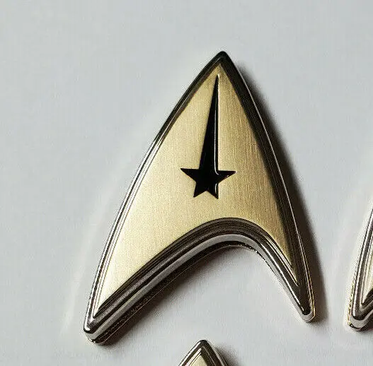 Gold and black Starfleet insignia pin.