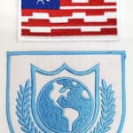 Two embroidered patches with a globe design.