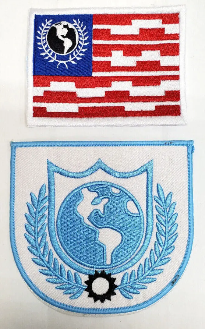 Two embroidered patches with a globe design.