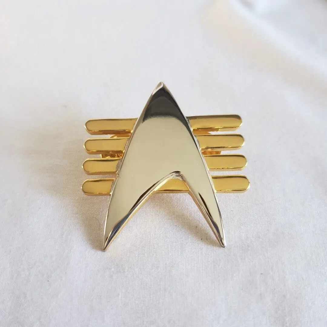 Gold and silver Starfleet pin.