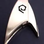 Silver Starfleet insignia with delta symbol.