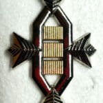 Silver and gold geometric badge with arrows.