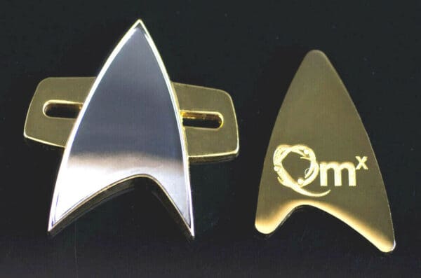 Gold and silver Starfleet insignia pins.