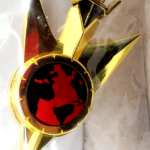 Gold pin with red globe and wings.