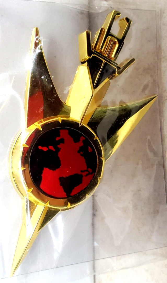 Gold pin with red globe and wings.