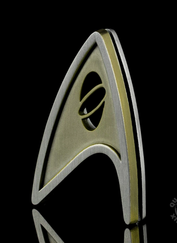 Gold Starfleet insignia with black background.
