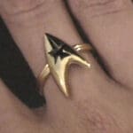 Gold Starfleet ring on finger.