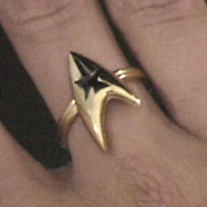 Gold Starfleet ring on finger.