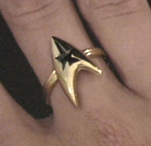 Gold Starfleet ring on finger.