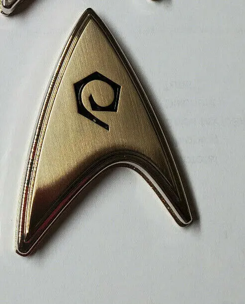 Gold Starfleet insignia with a black symbol.