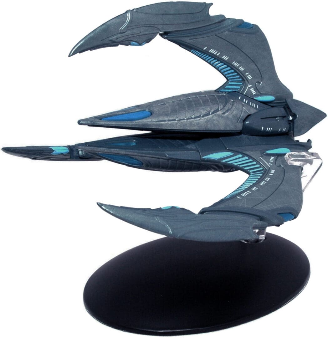 A grey and blue starship model on a stand.