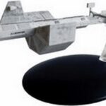 A gray model spaceship on a black stand.