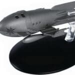 Grey model spaceship on a black stand.