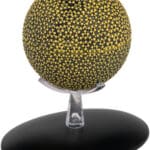 Yellow and black speckled sphere on stand.