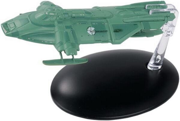 Green spaceship model on a black stand.