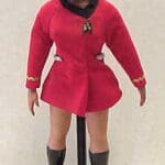 A female Star Trek doll in red uniform.