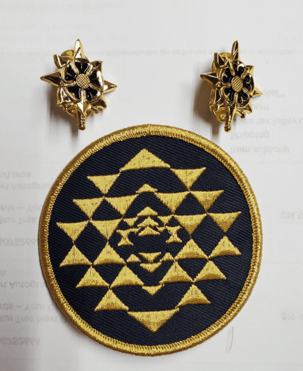 Gold embroidered patch with geometric pattern.