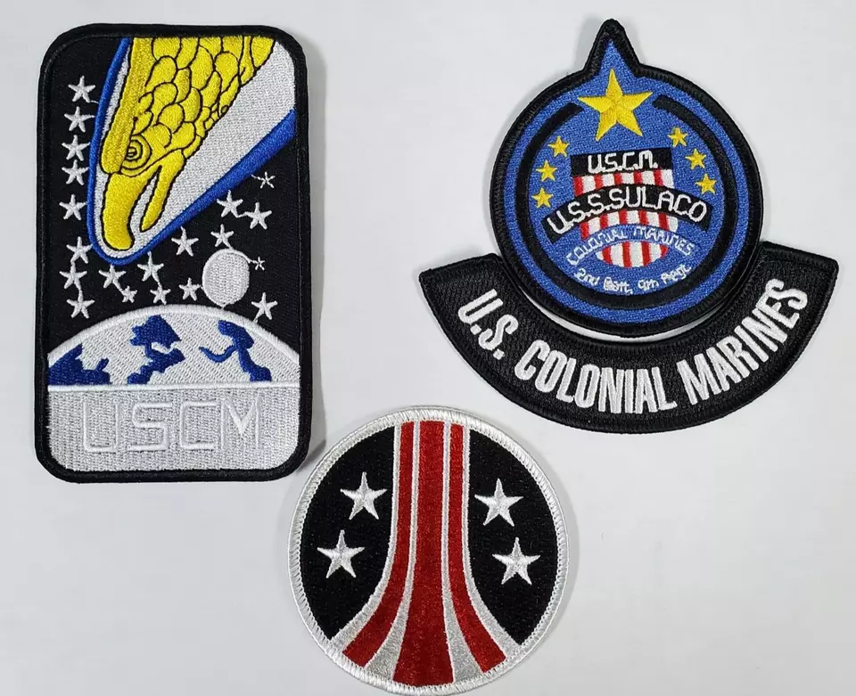 Three embroidered patches: space, military, and stars.