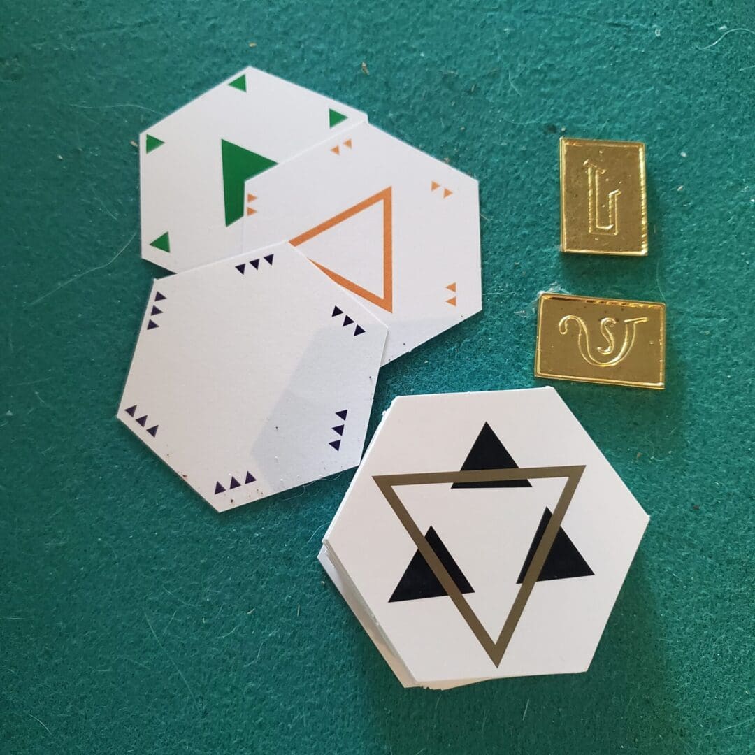 Hexagon game pieces with triangle symbols.